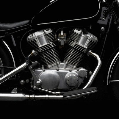 Motorcycle mechanic inspecting a motorcycle engine in a clean workshop